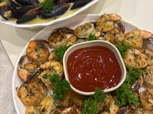 Garlic-seared shrimp plated with cocktail sauce