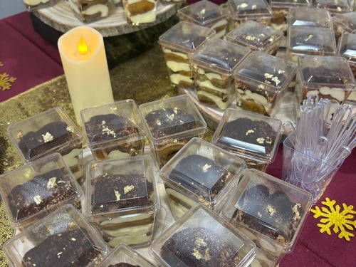 Individual tiramisu cups and gold-dusted chocolate desserts.