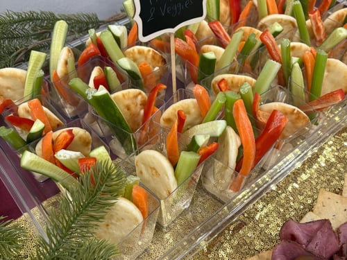 Individual hummus and pita veggie cups with fresh vegetables.