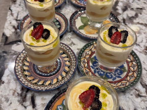 Individual lemon tiramisu desserts with fresh berries.
