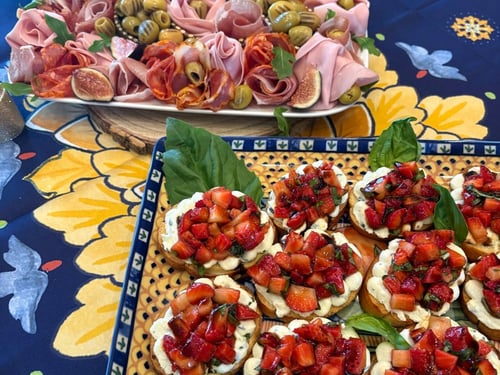 Close-up of strawberry bruschetta with fresh basil and charcuterie.