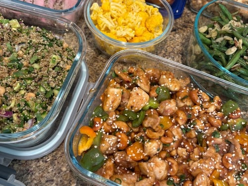 Close-up of cashew chicken, quinoa salad, and roasted vegetables