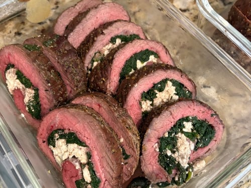 Close-up of sliced steak pinwheels filled with spinach and feta cheese.
