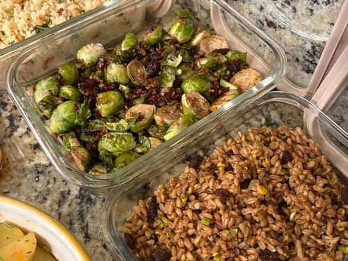 Glass containers of roasted brussels sprouts and farro pilaf.