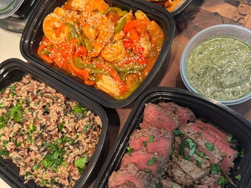 Assortment of prepared meals: chicken, shrimp, steak, rice, and pesto