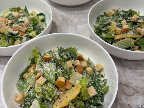 Individual servings of Caesar salad with croutons and Parmesan cheese.