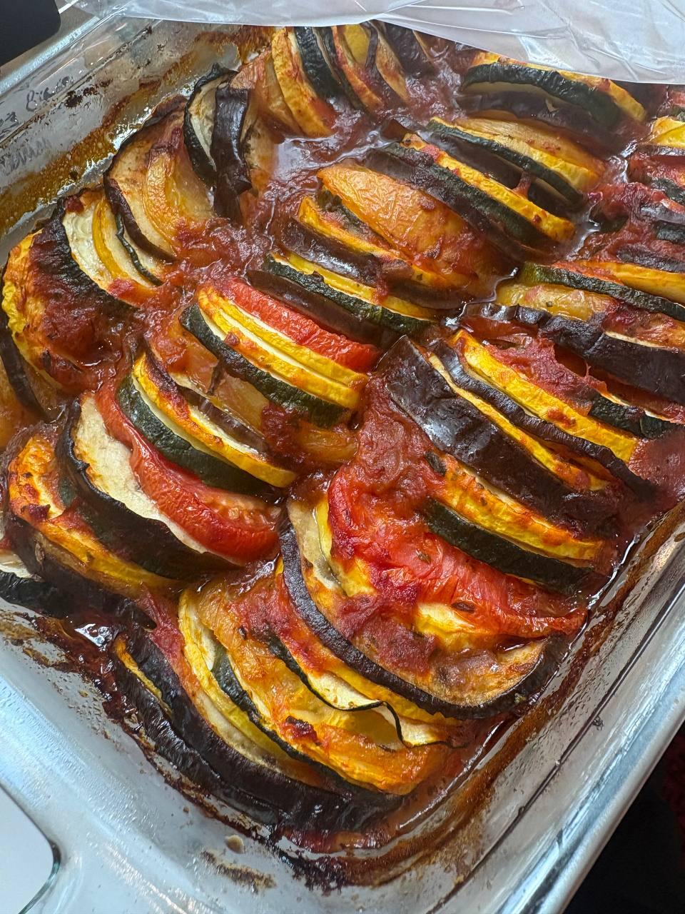 dish of zucchini and tomatoes is being cooked in a pan