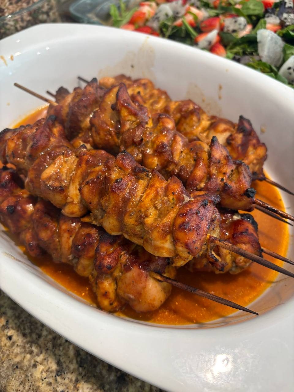 white bowl filled with marinated meat skewers
