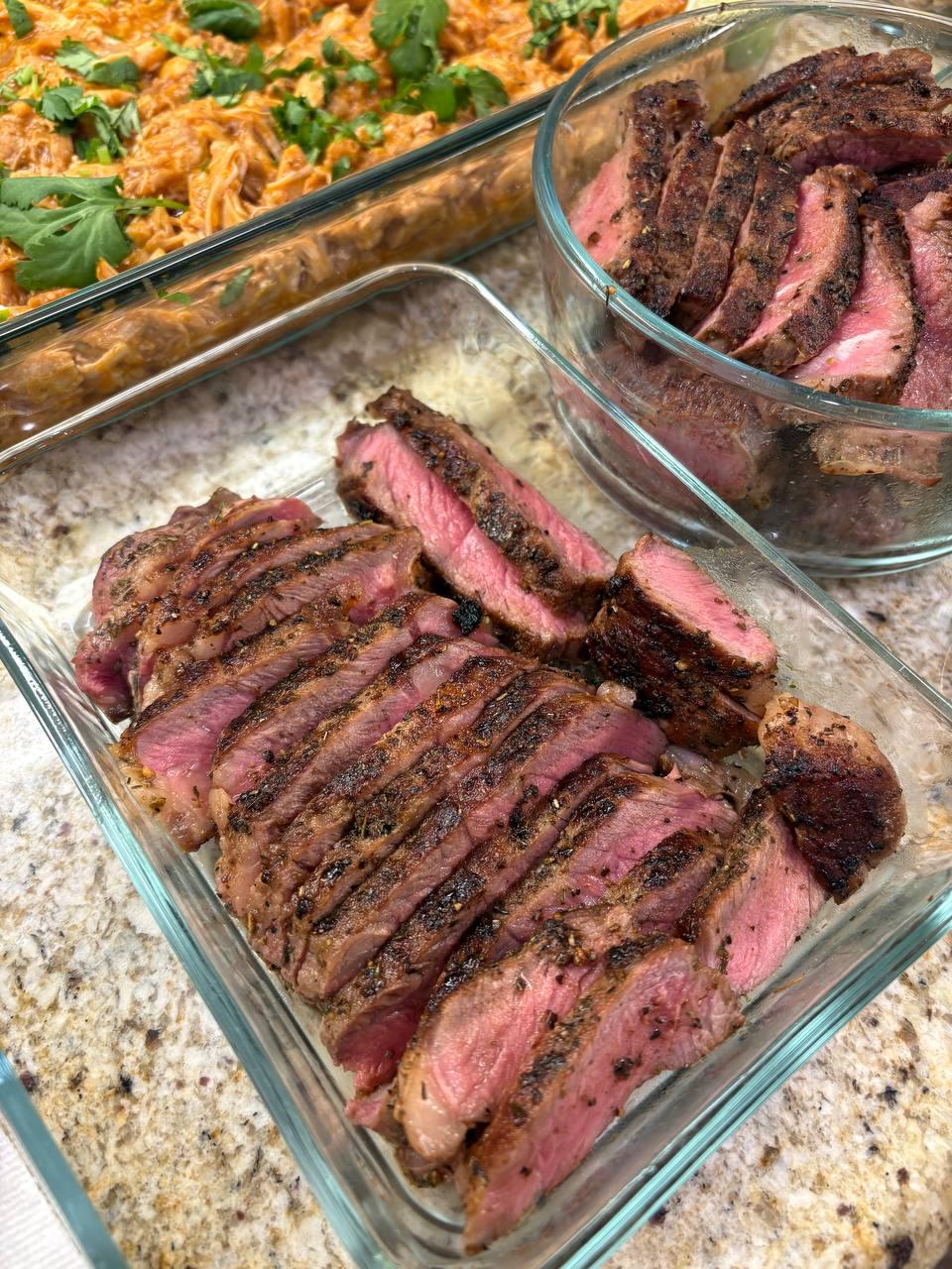 dinner table with a variety of food, including a large steak