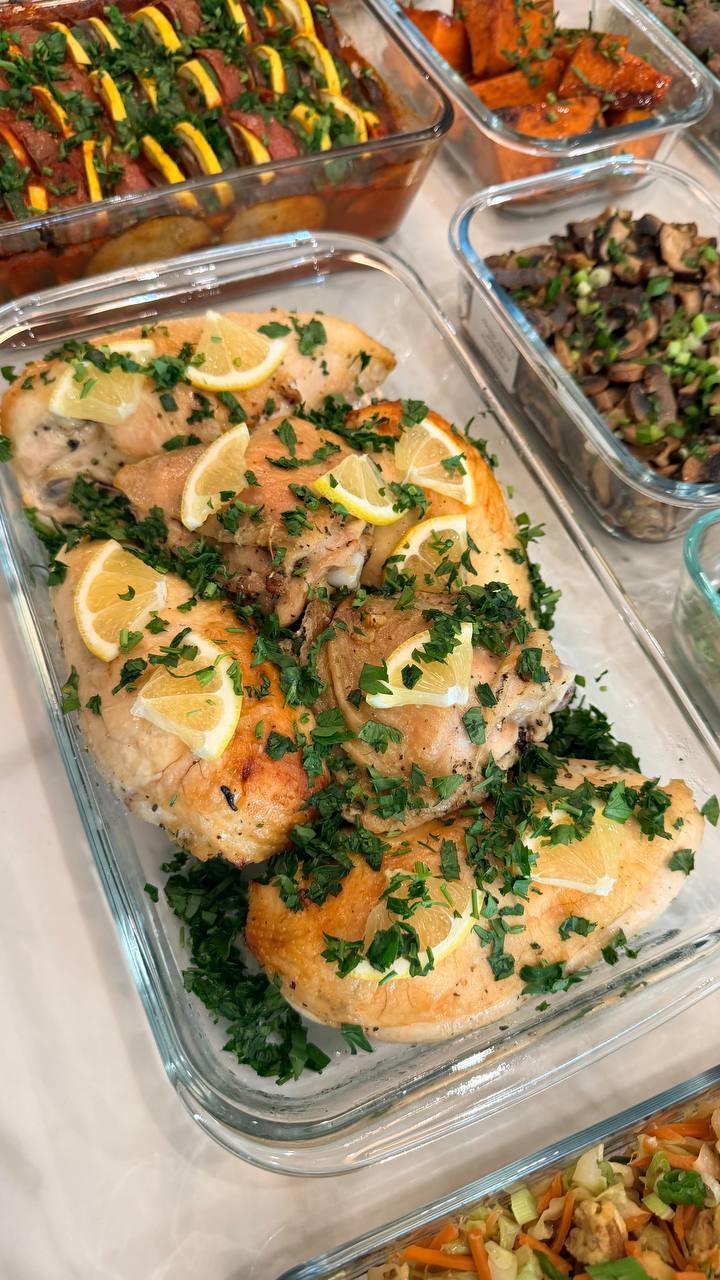 dish of chicken with lemon slices and herbs
