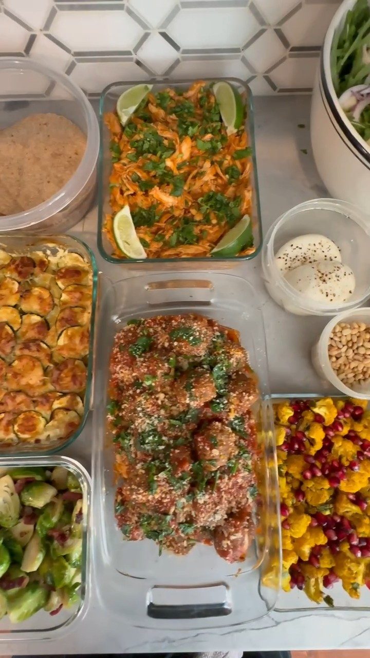 table filled with various dishes, including a bowl of meatballs