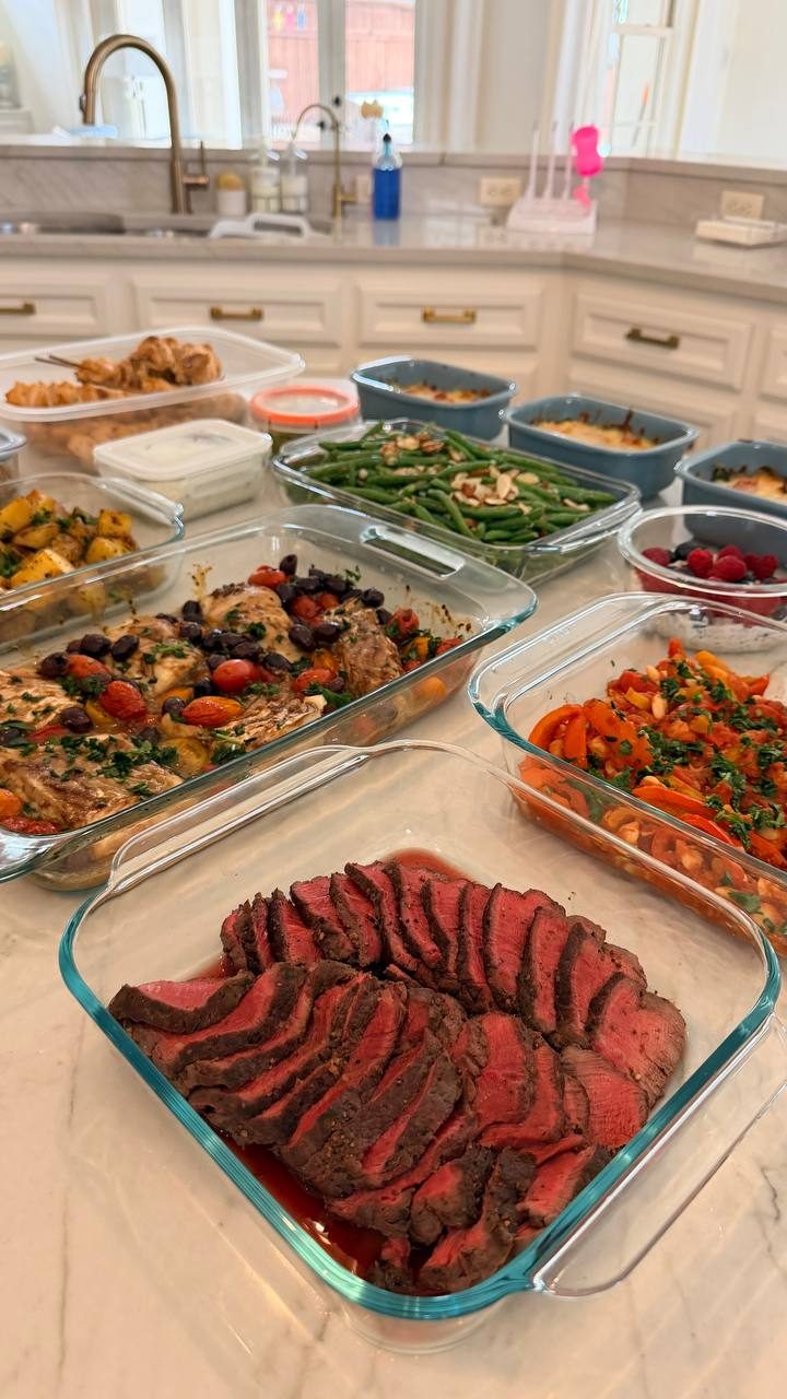 table filled with various dishes, including a large tray of meat