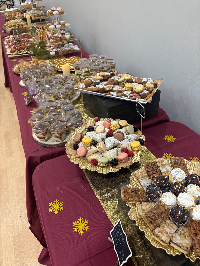 Long buffet table laden with various desserts and sweet treats.