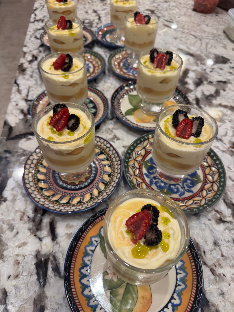 Individual lemon tiramisu desserts with fresh berries.