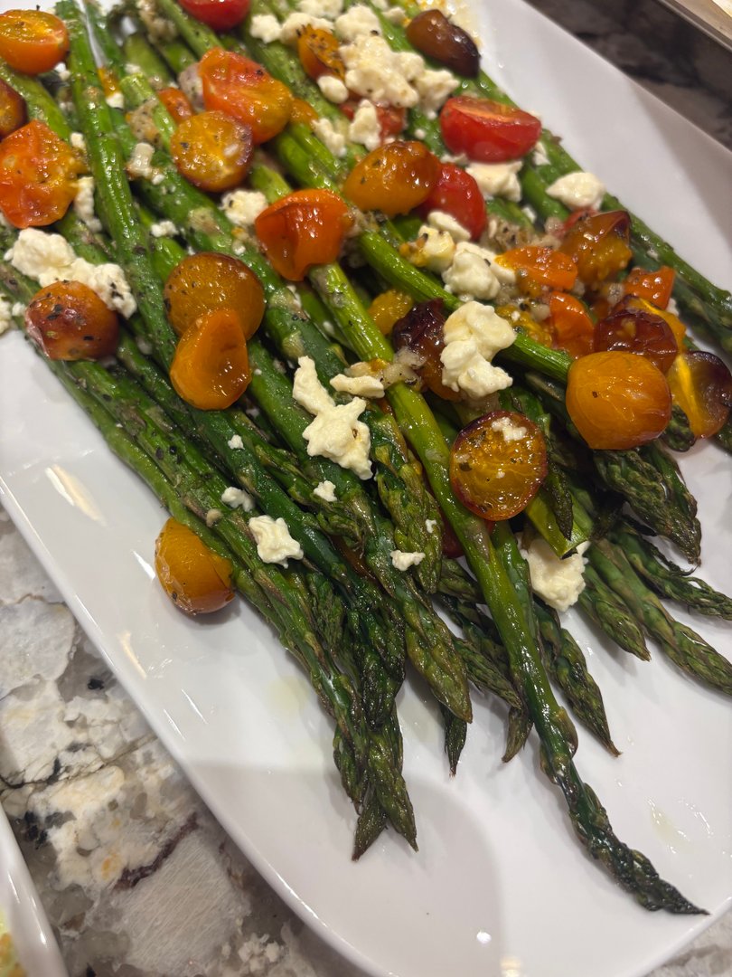 Close-up of roasted asparagus with blistered tomatoes and feta.