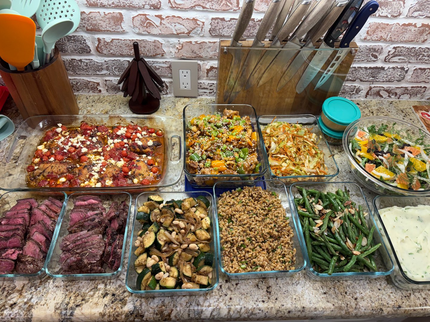 A full meal prep spread of Mediterranean and global fusion dishes.