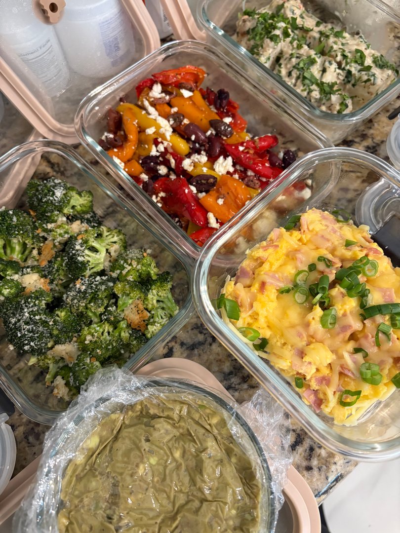Prepared meals including roasted broccoli, cheesy eggs, and bell peppers with feta.