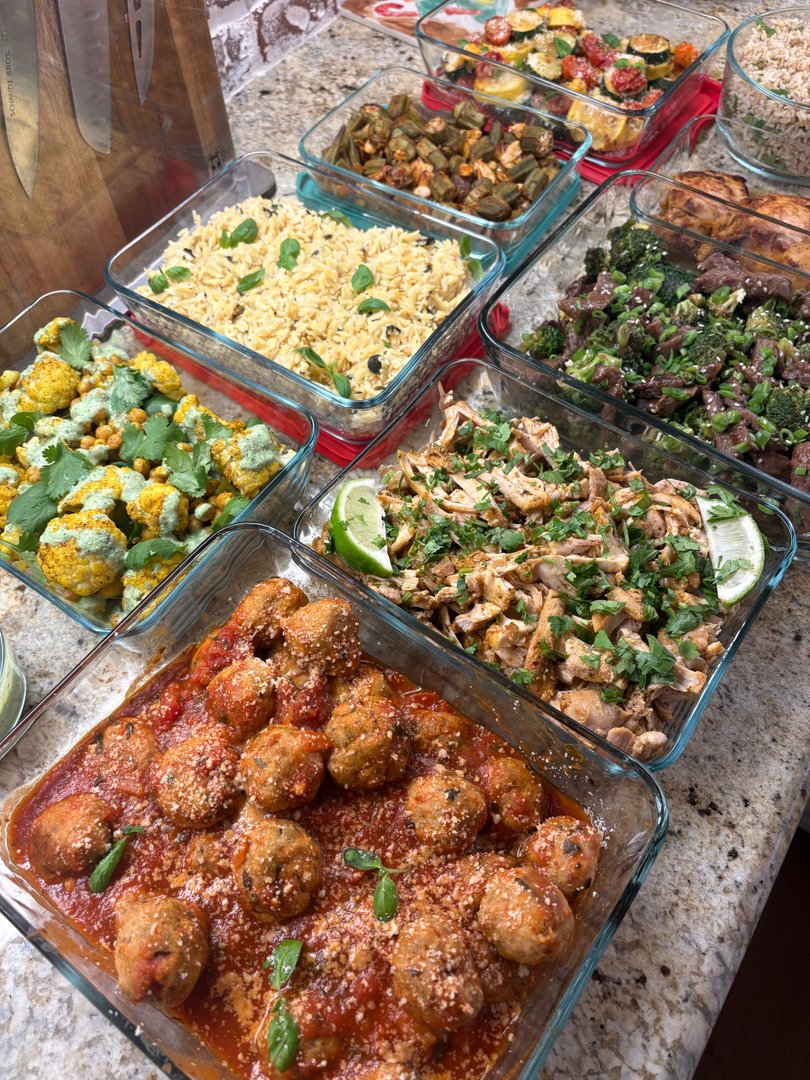 Assortment of globally-inspired meal prep dishes in glass containers.