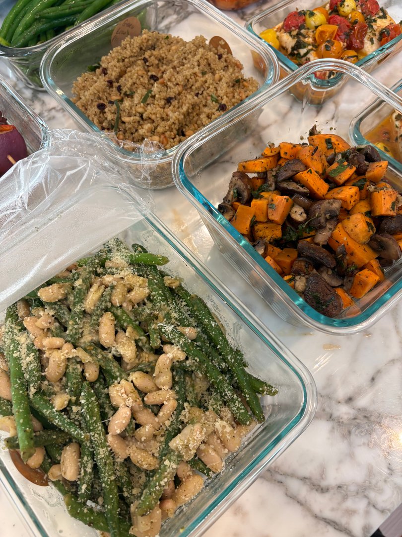 Glass containers with green beans and white beans, and roasted sweet potatoes and mushrooms.