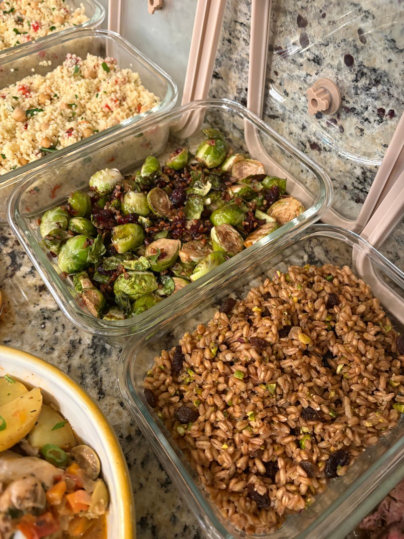 Glass containers of roasted brussels sprouts and farro pilaf.