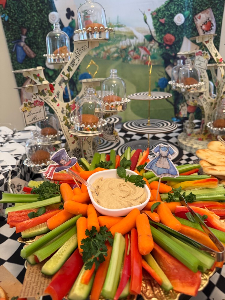 Veggie platter with carrots, celery, peppers, and hummus.