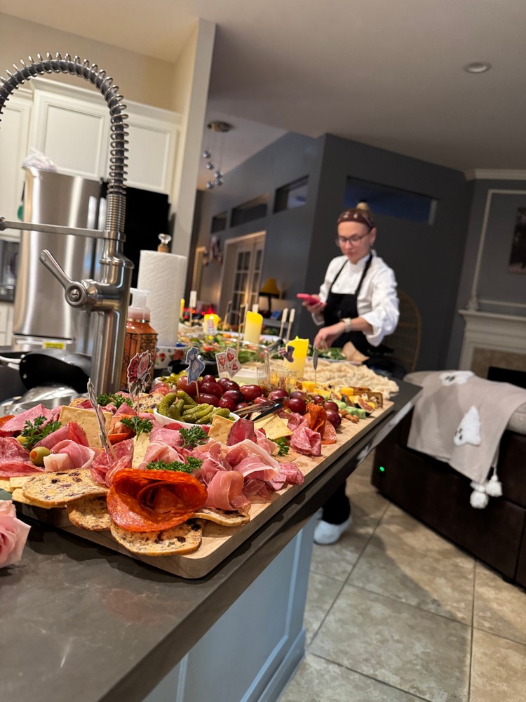 Chef Ana meticulously arranging items on a large charcuterie board