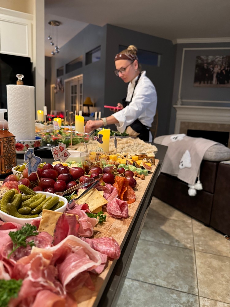 Chef Ana focused on arranging the charcuterie board in a well-lit kitchen