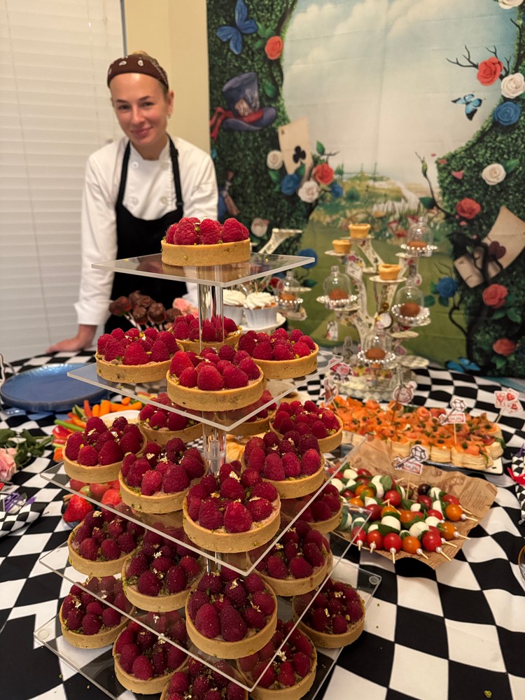 Chef Ana with raspberry tarts and a buffet spread