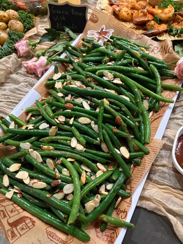 Garlicky green beans with sliced almonds on a serving platter