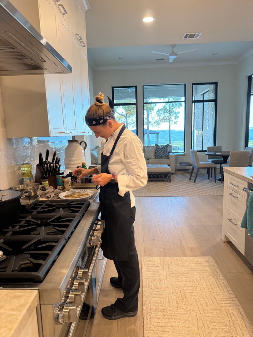 Chef Ana preparing food in a modern kitchen overlooking a lake.