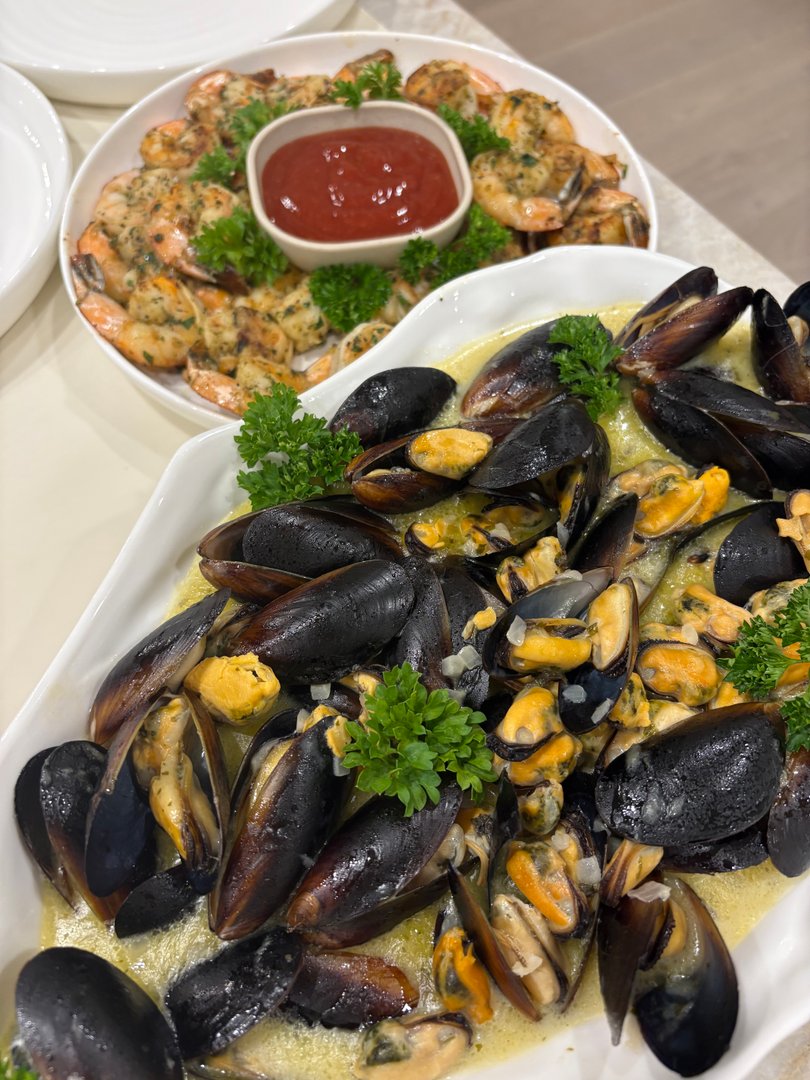 Platter of white wine and butter mussels with parsley garnish.